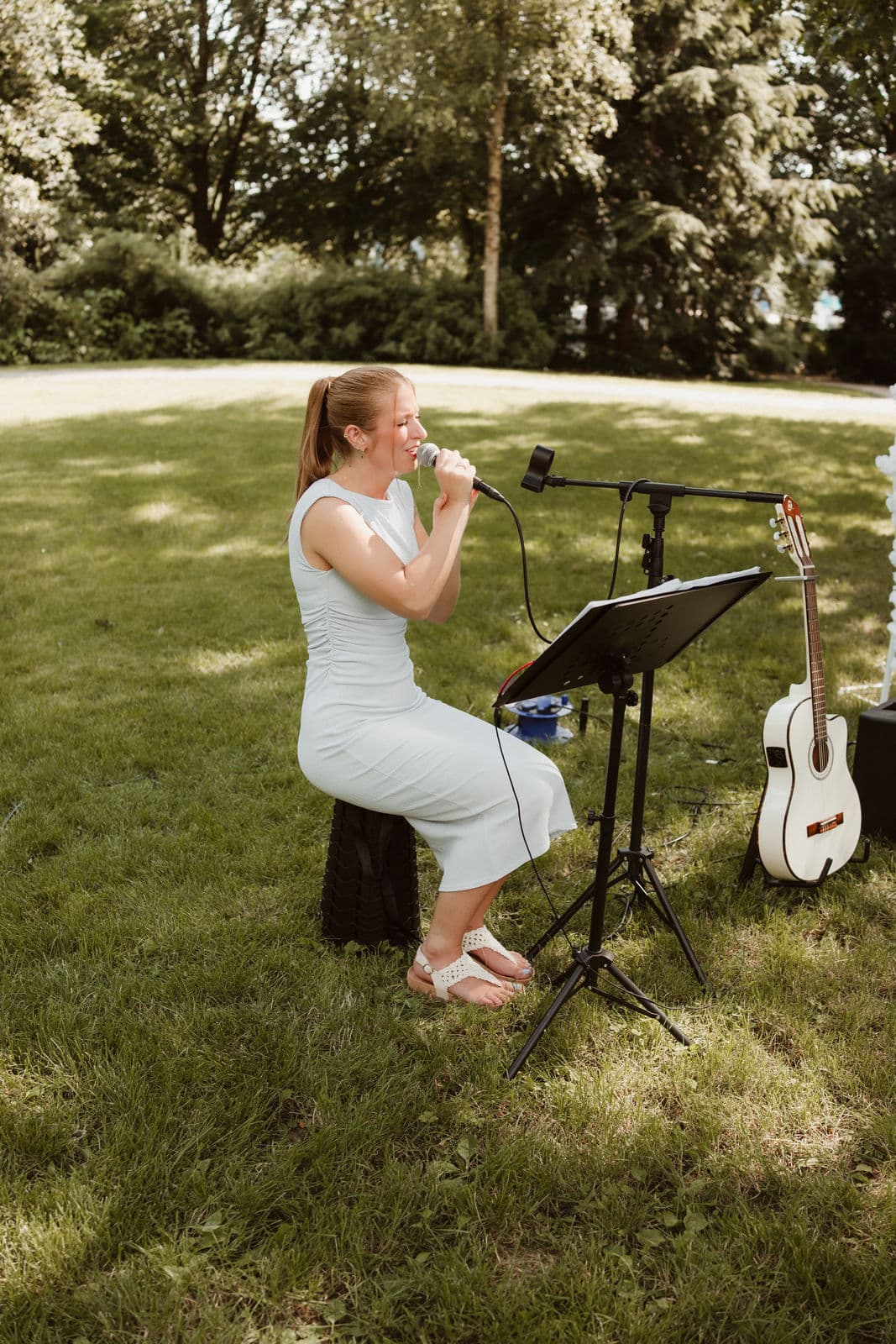 Live-Gesang bei einer Trauung im Garten, daneben steht die Gitarre bereit